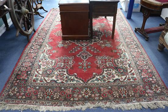 A modern Persian red-ground carpet with polychrome figured floral central medallion, 330cm x 220cm